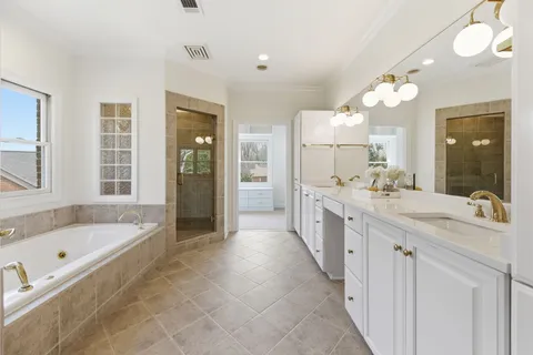 a large bathroom with a granite countertop tub a double vanity sink a large mirror and a bathtub