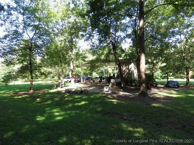 a view of a backyard with table and chairs and a fire pit