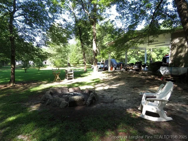 a view of a house with backyard and sitting area
