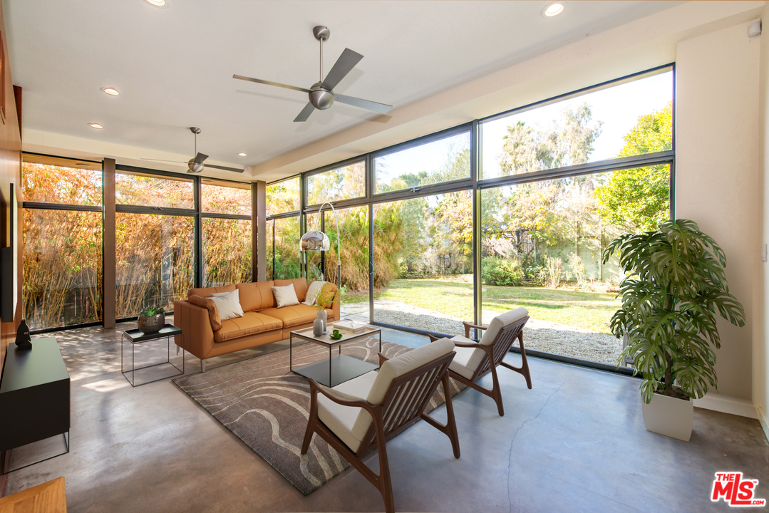a living room with furniture and floor to ceiling windows