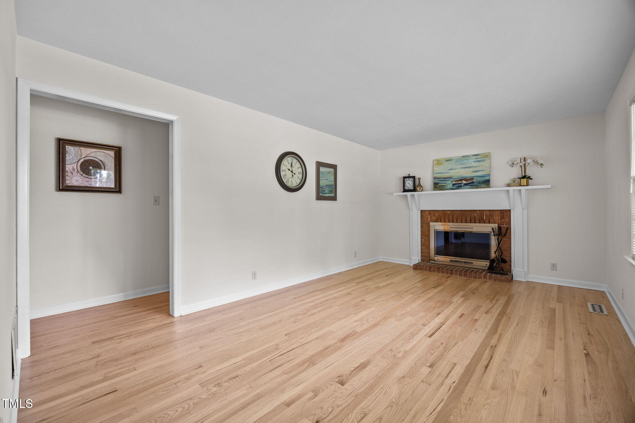 2809 Bardwell Road Raleigh, NC 27604 - Photo 3 of 19 an empty room with wooden floor and fireplace