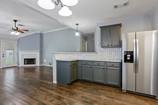 a spacious bathroom with a granite countertop sink a mirror and a refrigerator