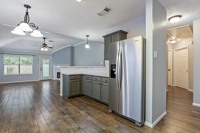 a kitchen with a refrigerator and a stove top oven