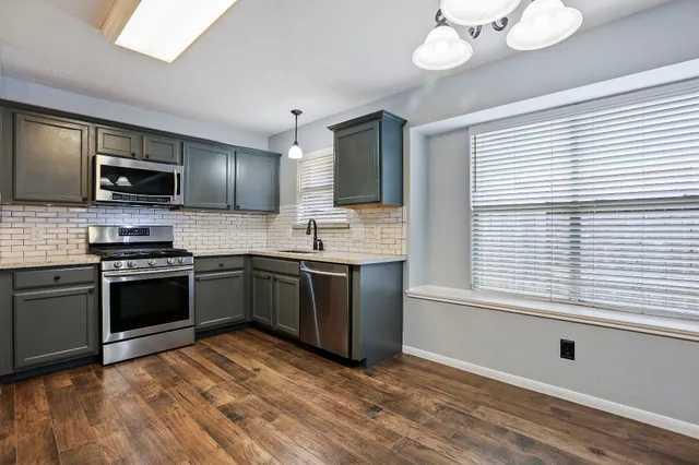 a kitchen with stainless steel appliances granite countertop a stove and a sink