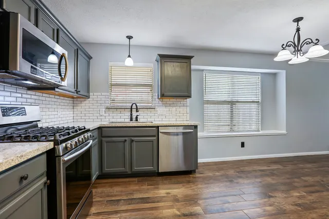 a kitchen with stainless steel appliances granite countertop a sink stove and oven