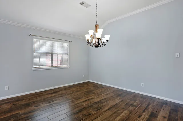 a view of a room with wooden floor chandelier and window