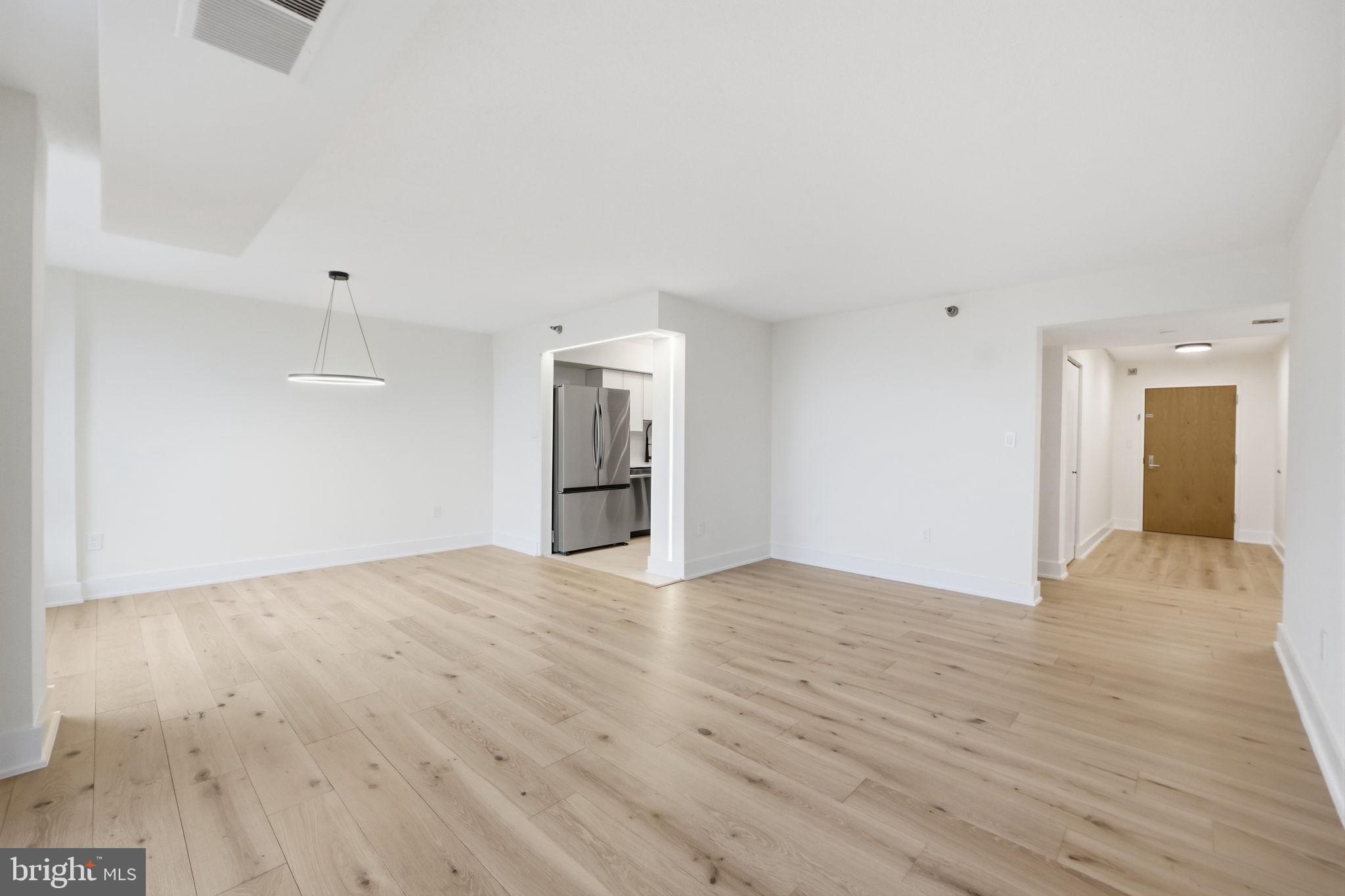 1808 Old Meadow Road, Unit 1201 McLean, VA 22102 - Photo 10 of 37 a view of empty room with wooden floor and kitchen