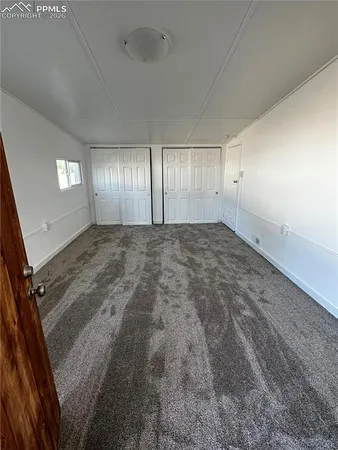 an empty room with windows & cabinet view