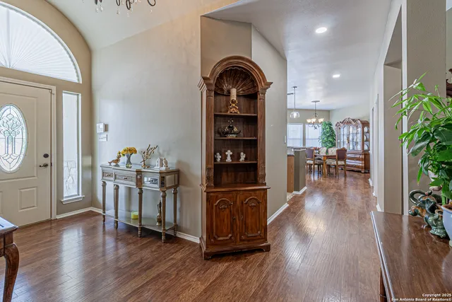 a view of a dining room with furniture a chandelier and wooden floor
