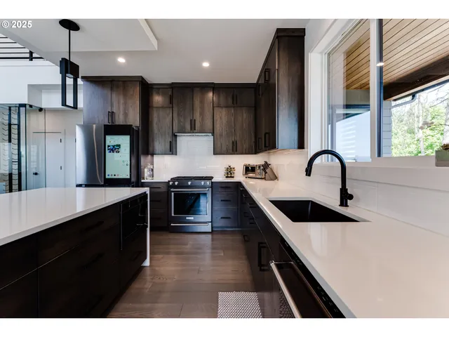 a kitchen with kitchen island granite countertop a sink a counter top space stainless steel appliances and cabinets