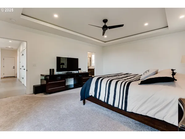 a spacious bedroom with a bed and a flat screen tv