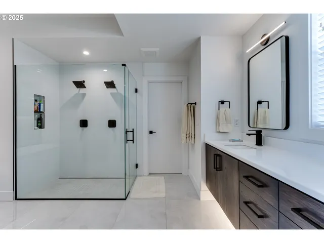 a bathroom with a double vanity sink mirror and shower