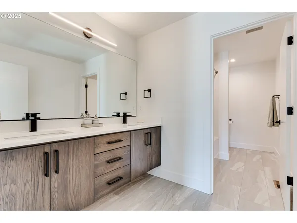 a bathroom with a double vanity sink a mirror and a shower