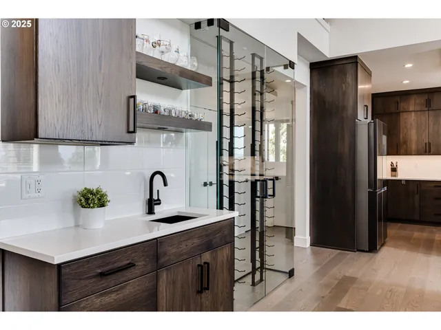 a kitchen with stainless steel appliances granite countertop a sink refrigerator and cabinets