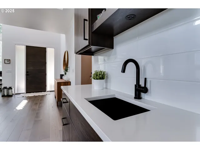 a kitchen with stainless steel appliances a sink a counter space and cabinets