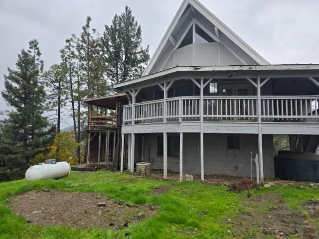 a view of a house with a yard and a large tree