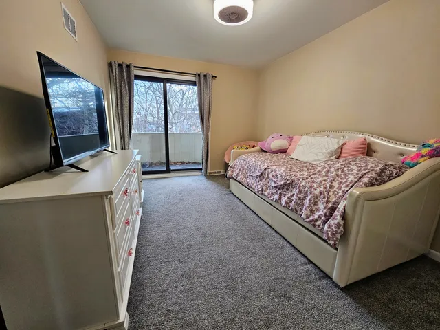 a bed room with a bed and a flat tv screen