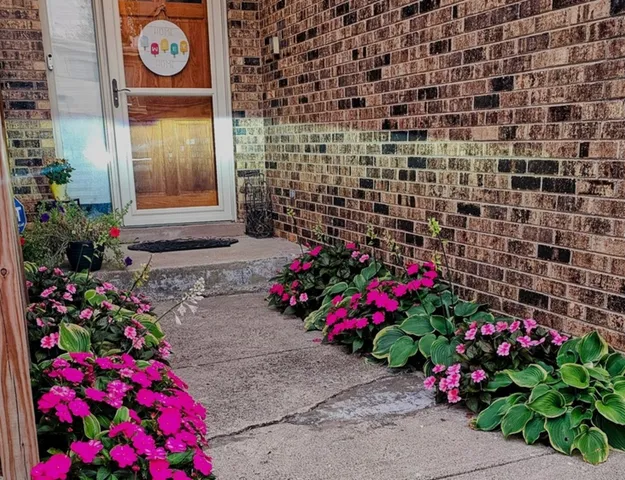 a flower garden in a backyard of a house