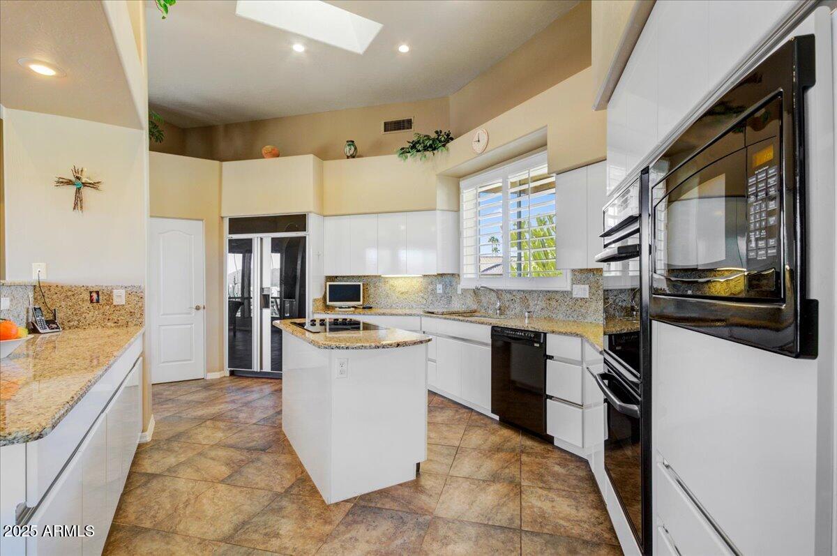 25633 North Abajo Drive Rio Verde, AZ 85263 - Photo 19 of 49 a large kitchen with stainless steel appliances kitchen island a large counter top a stove a sink and a refrigerator