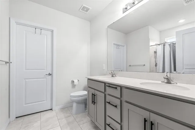 a bathroom with a granite countertop sink a toilet and a mirror