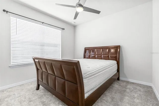 a bed sitting in a bedroom next to a window