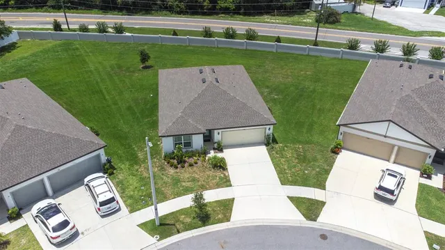an aerial view of a house with a garden and lake view