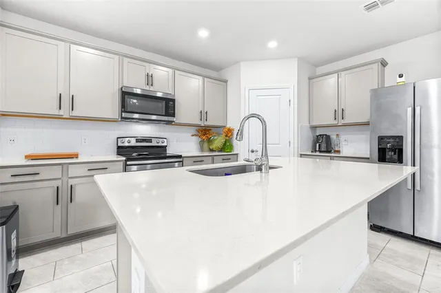 a kitchen with stainless steel appliances a stove refrigerator sink and cabinets