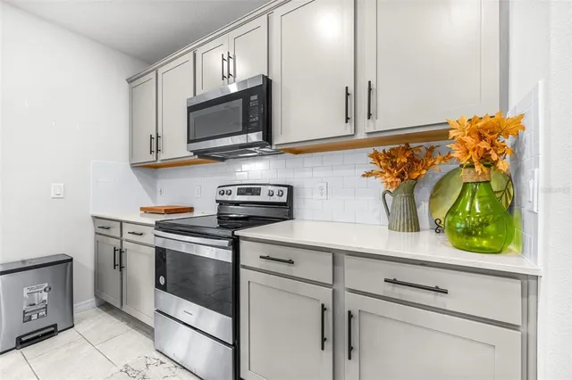 a kitchen with stainless steel appliances white cabinets and a stove top oven