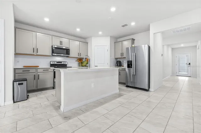 a kitchen with stainless steel appliances granite countertop a refrigerator sink and cabinets