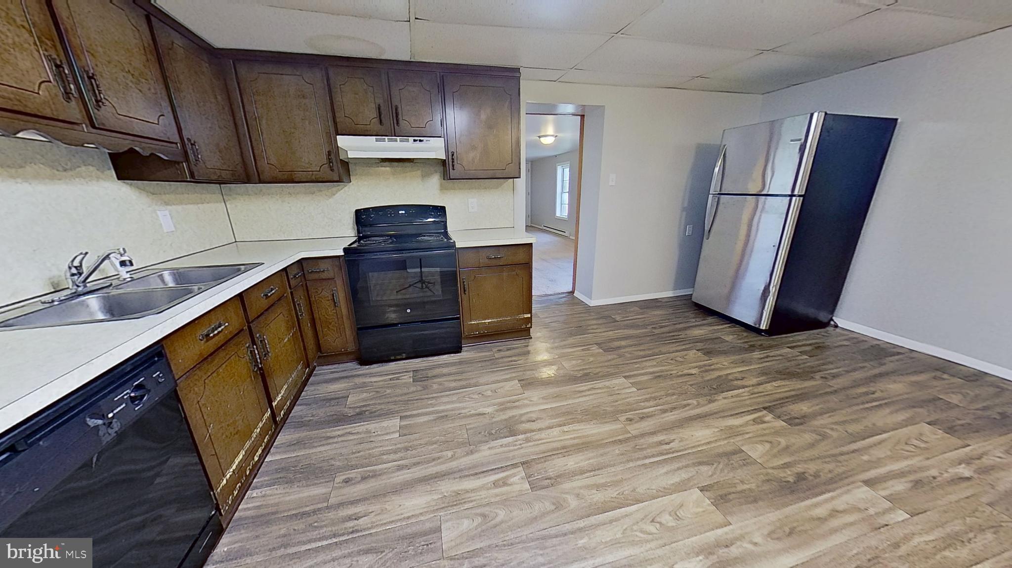 85 1st Avenue, Unit 1 Red Lion, PA 17356 - Photo 2 of 8 a kitchen with granite countertop a refrigerator a sink and wooden cabinets