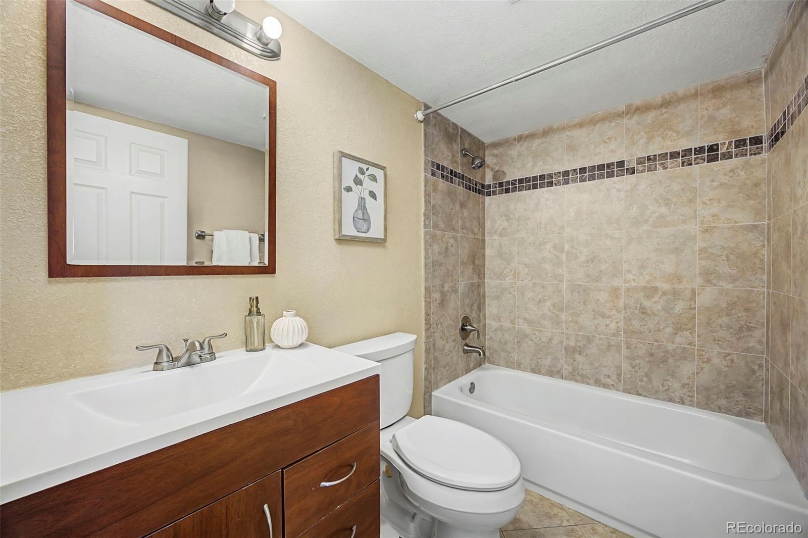 4394 South Van Gordon Way Morrison, CO 80465 - Photo 16 of 20 a bathroom with a sink mirror toilet and bathtub