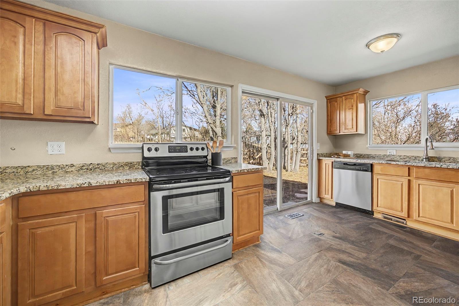 4394 South Van Gordon Way Morrison, CO 80465 - Photo 8 of 20 a kitchen with stainless steel appliances granite countertop a stove a sink and a microwave