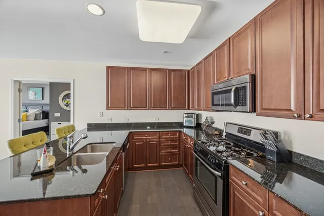 a kitchen with granite countertop a stove sink and cabinets