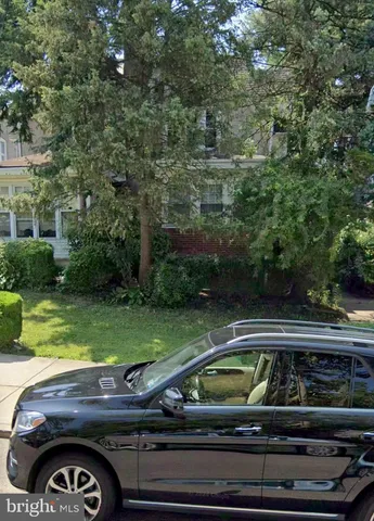 a view of yard with car parked and deck