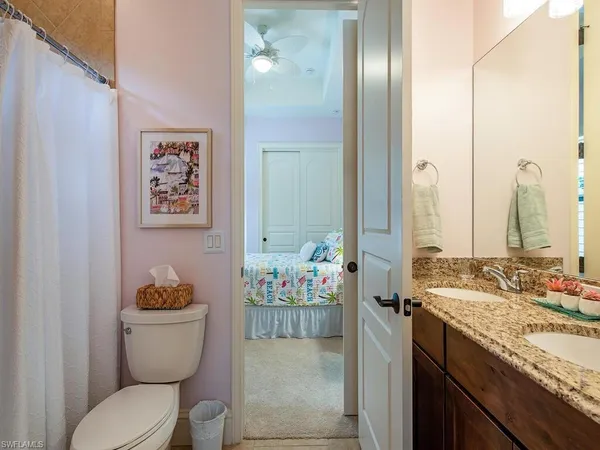 a bathroom with a granite countertop sink mirror vanity and toilet