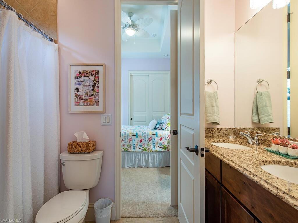 8000 Cordoba Place Naples, FL 34113 - Photo 11 of 16 a bathroom with a granite countertop sink mirror vanity and toilet