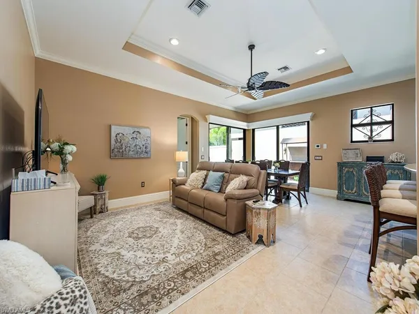 a living room with furniture a dining table and a chandelier