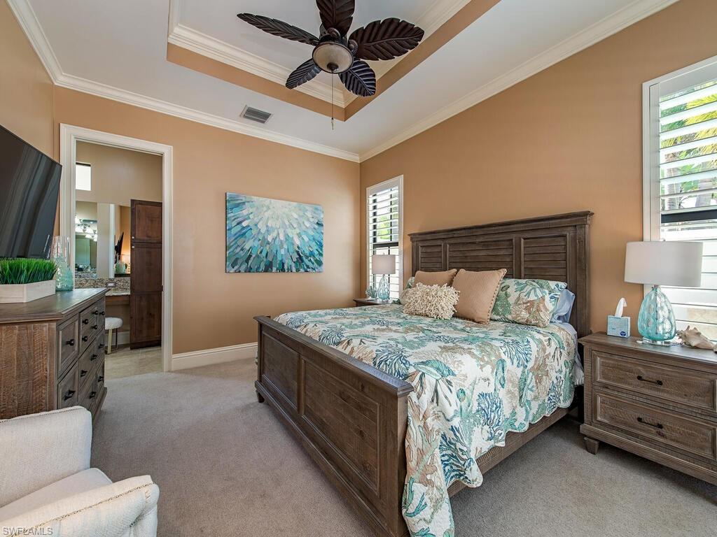 8000 Cordoba Place Naples, FL 34113 - Photo 8 of 16 a bedroom with a bed a mirror on dresser and a chandelier