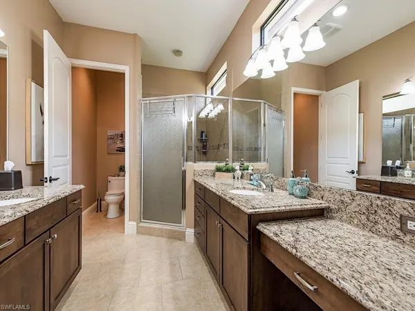 a bathroom with a granite countertop sink a large mirror and a shower