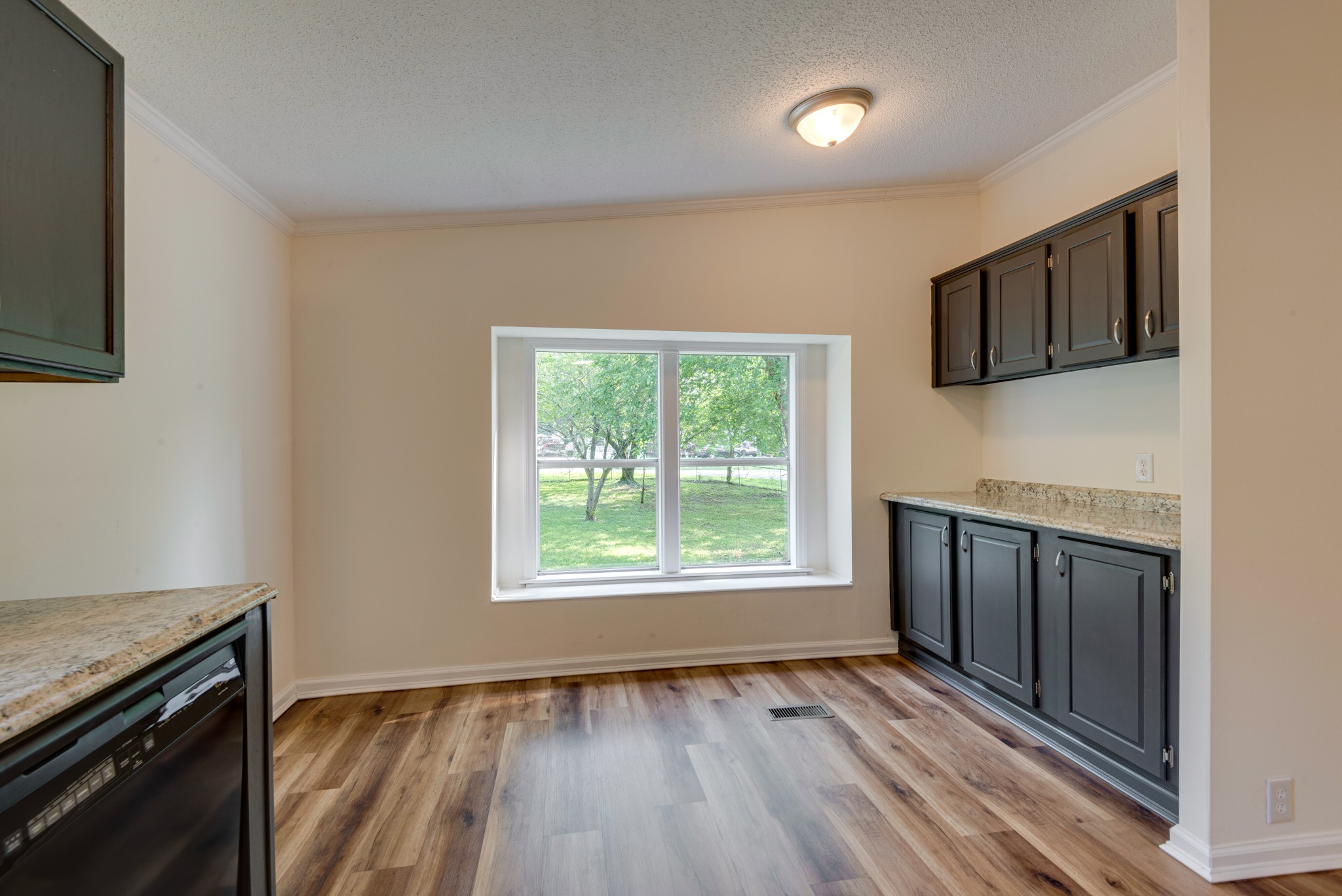 211 Hillcrest Road Kingston Springs, TN 37082 - Photo 11 of 28 an empty room with wooden floor cabinet and windows