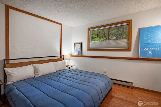 a bedroom with a bed and a painting on the wall