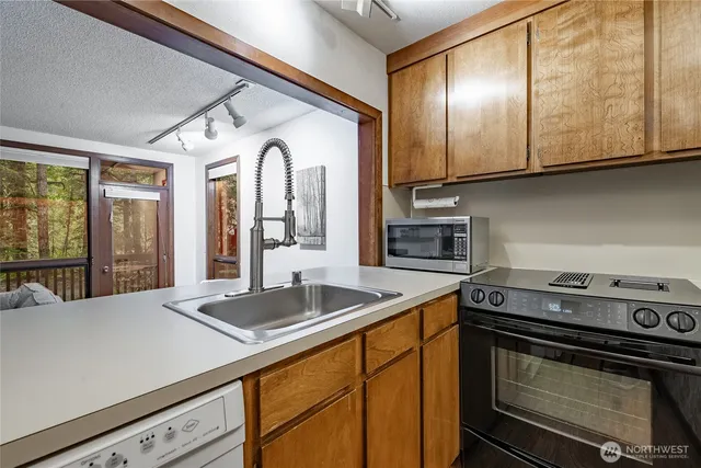 a kitchen with granite countertop cabinets stainless steel appliances and wooden floor