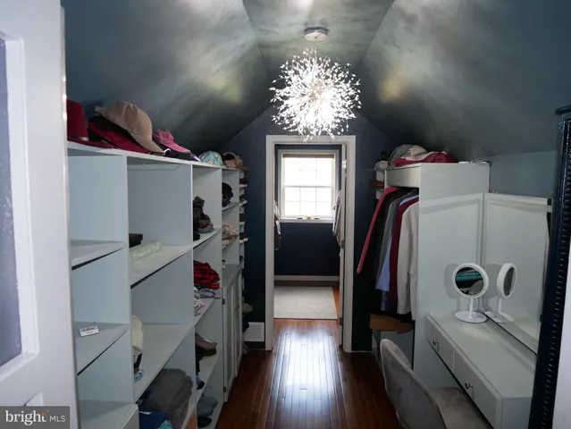 a bedroom with a bed and a lamp on dresser