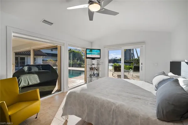 a bedroom with a bed a couch and large window