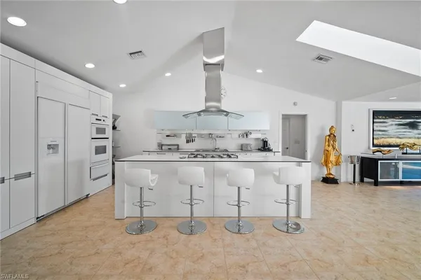 a kitchen with stainless steel appliances granite countertop a sink and a refrigerator