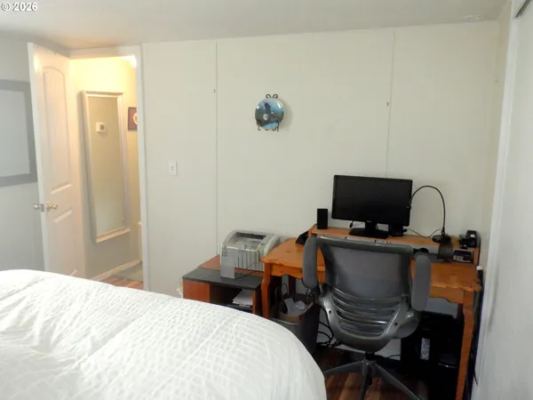 a bedroom with a bed and a computer on a table