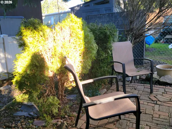 a backyard of a house with table and chairs and potted plants
