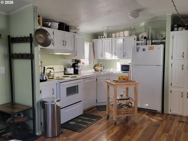 a kitchen with a refrigerator and white cabinets
