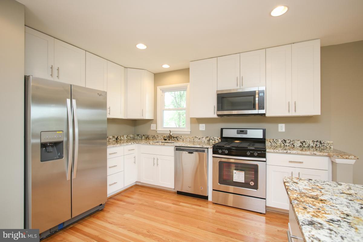 6903 Presley Road Lanham, MD 20706 - Photo 9 of 28 a kitchen with stainless steel appliances granite countertop a refrigerator stove and microwave