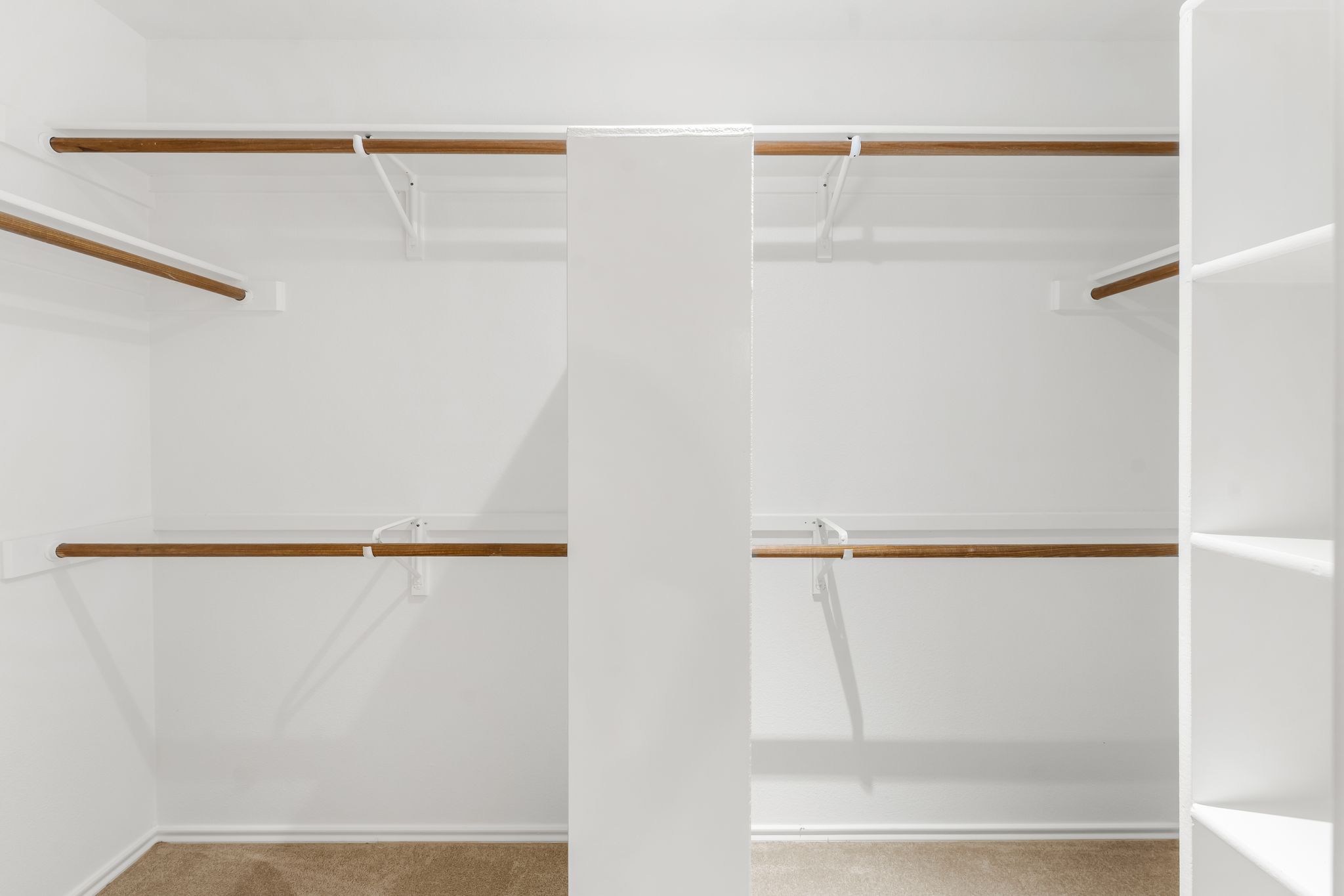 3704 Caney Creek Road Austin, TX 78732 - Photo 29 of 40 Ample storage solutions abound in this well-appointed closet, featuring multiple hanging rods and integrated shelving for optimal organization.